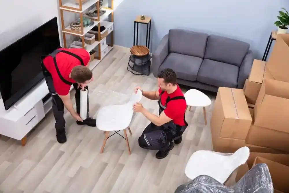 two men packing furniture for moving services